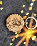 Porte-clés rond en bois gravé d'une figure religieuse auréolée