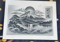 Plaque décorative gravée représentant le mont Fuji, un lac et des vagues